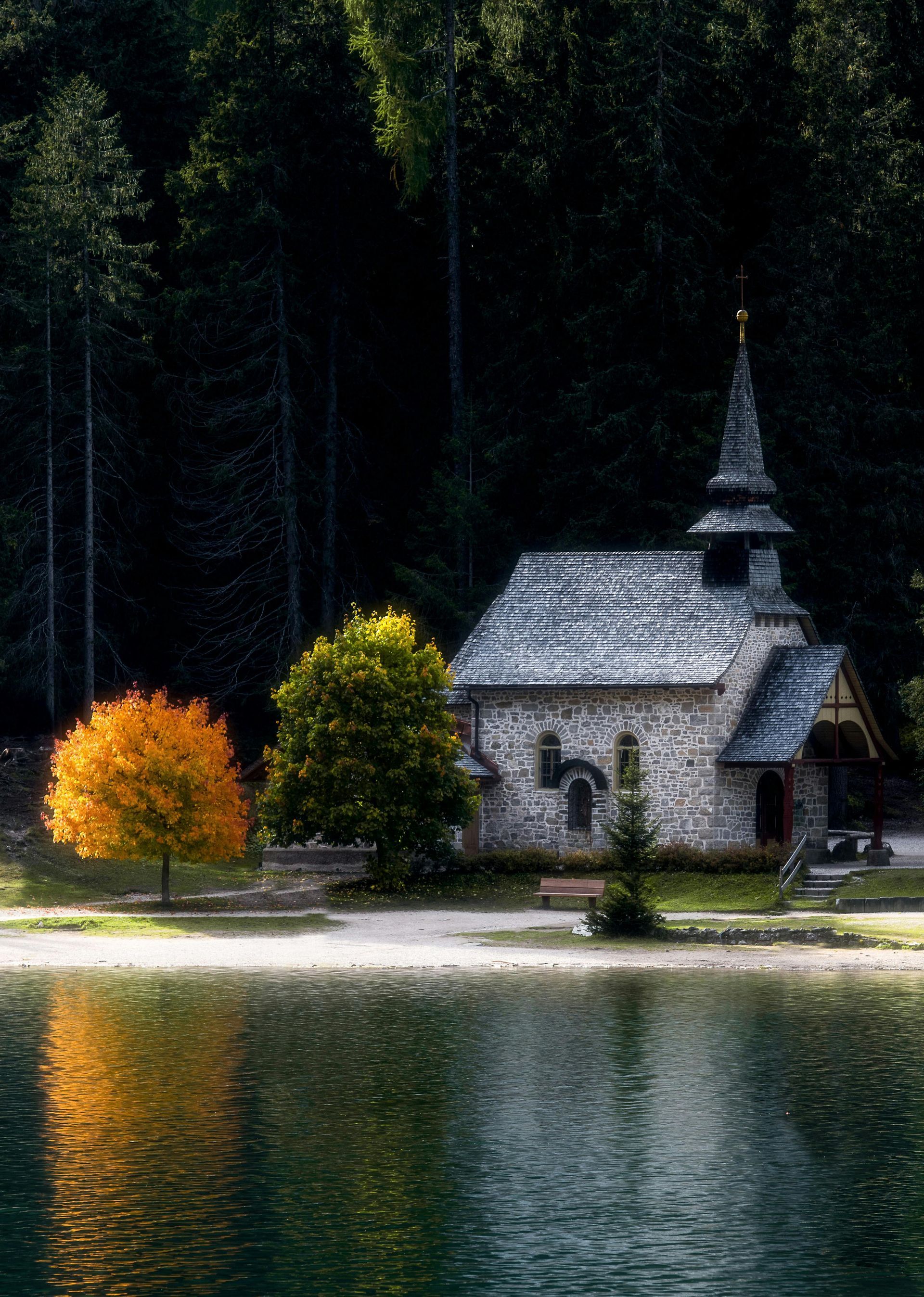 A small church sits on the shore of a lake