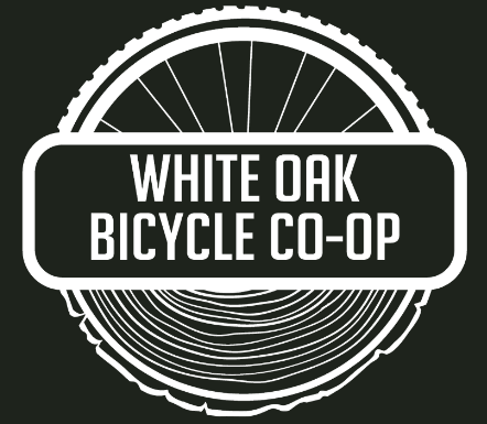 The logo for white oak bicycle co-op shows a bicycle wheel and a tree stump.