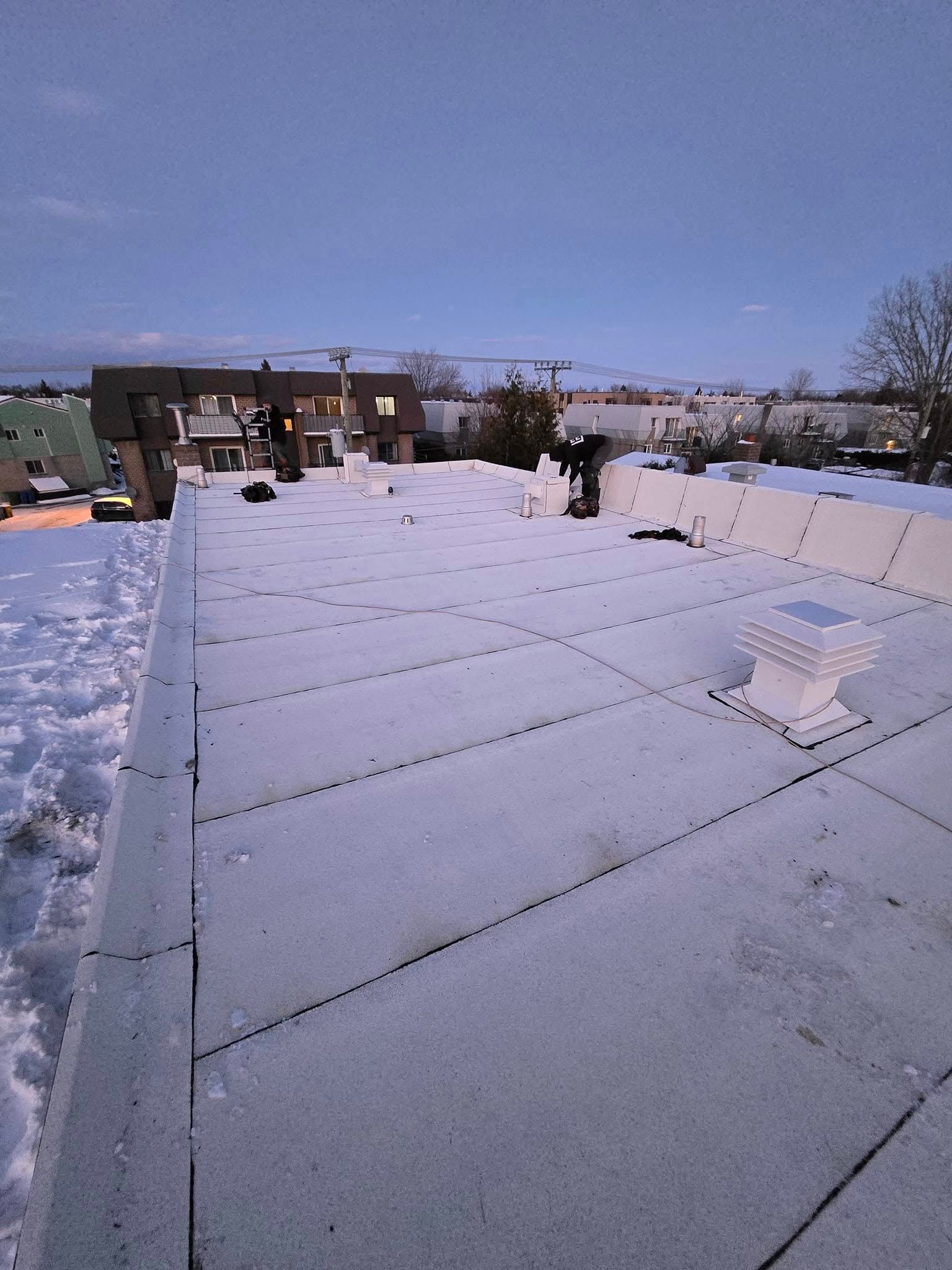 Un toit enneigé avec une cheminée dessus