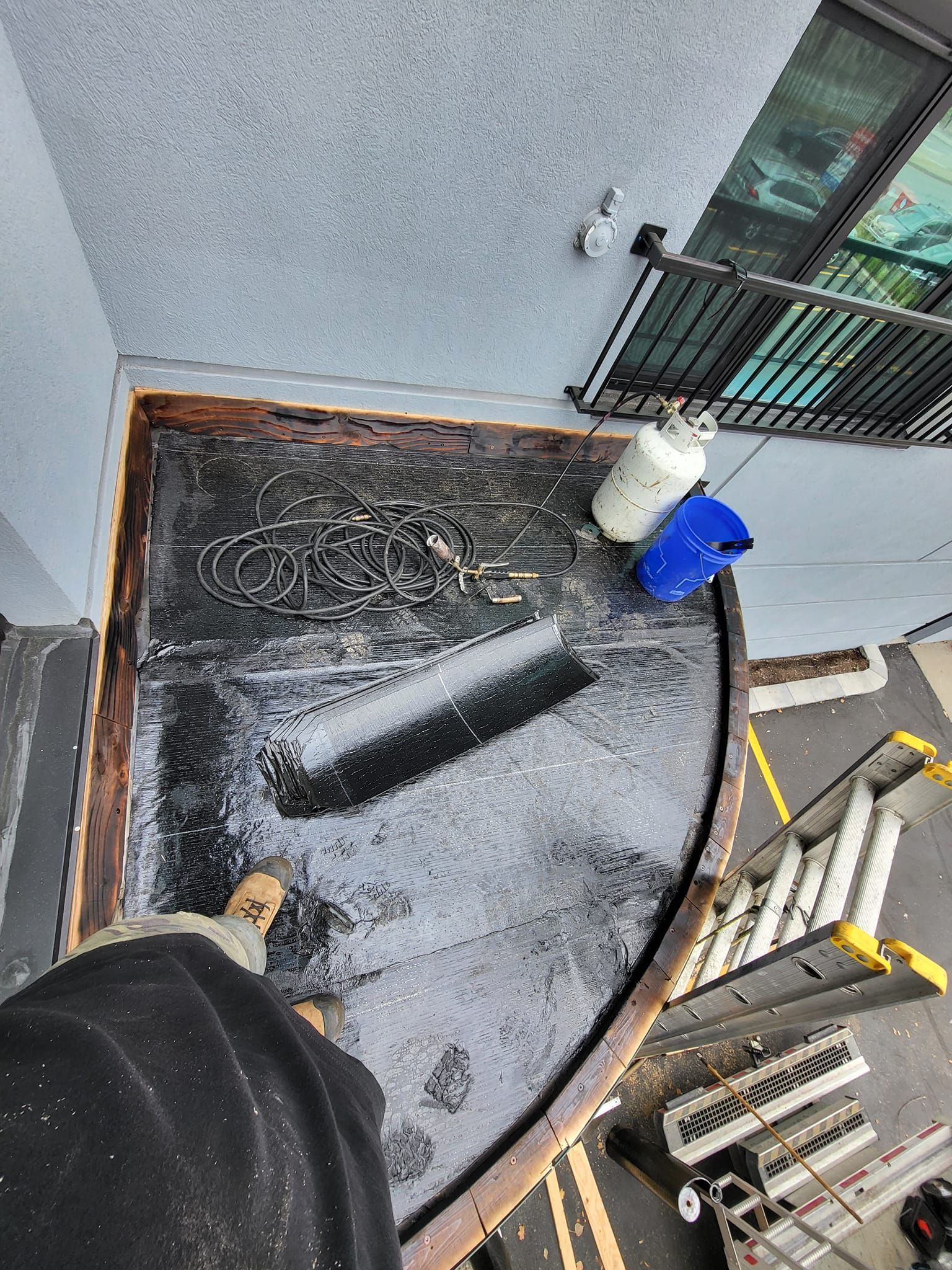 Une personne se tient sur un balcon à côté d'un bâtiment.