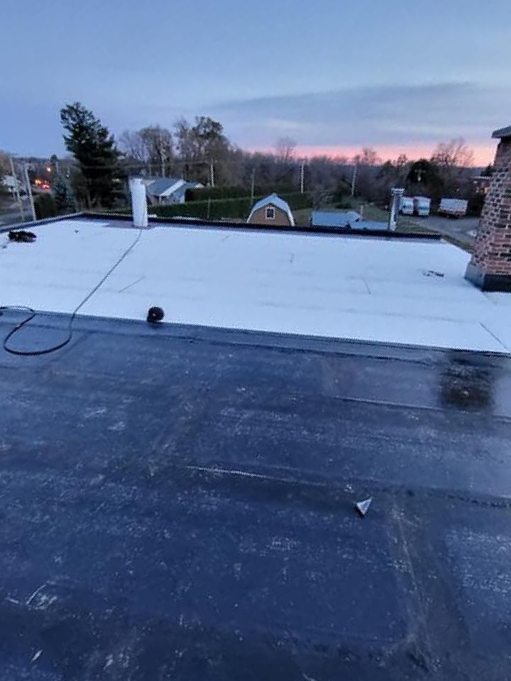 Un toit noir et blanc avec une cheminée au-dessus.