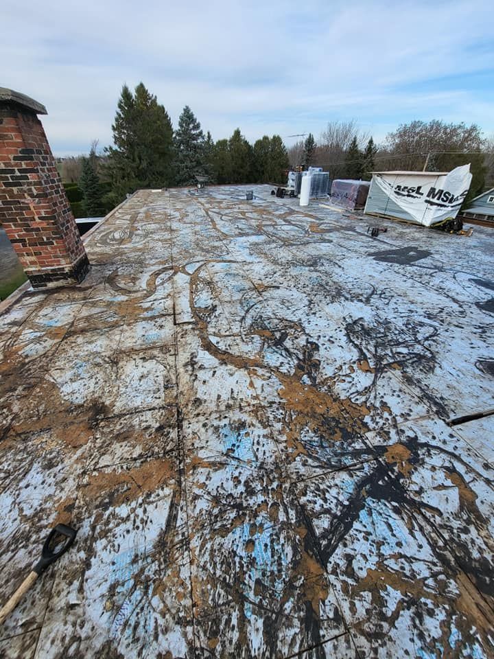 Un toit avec une cheminée en brique et une pelle dessus.