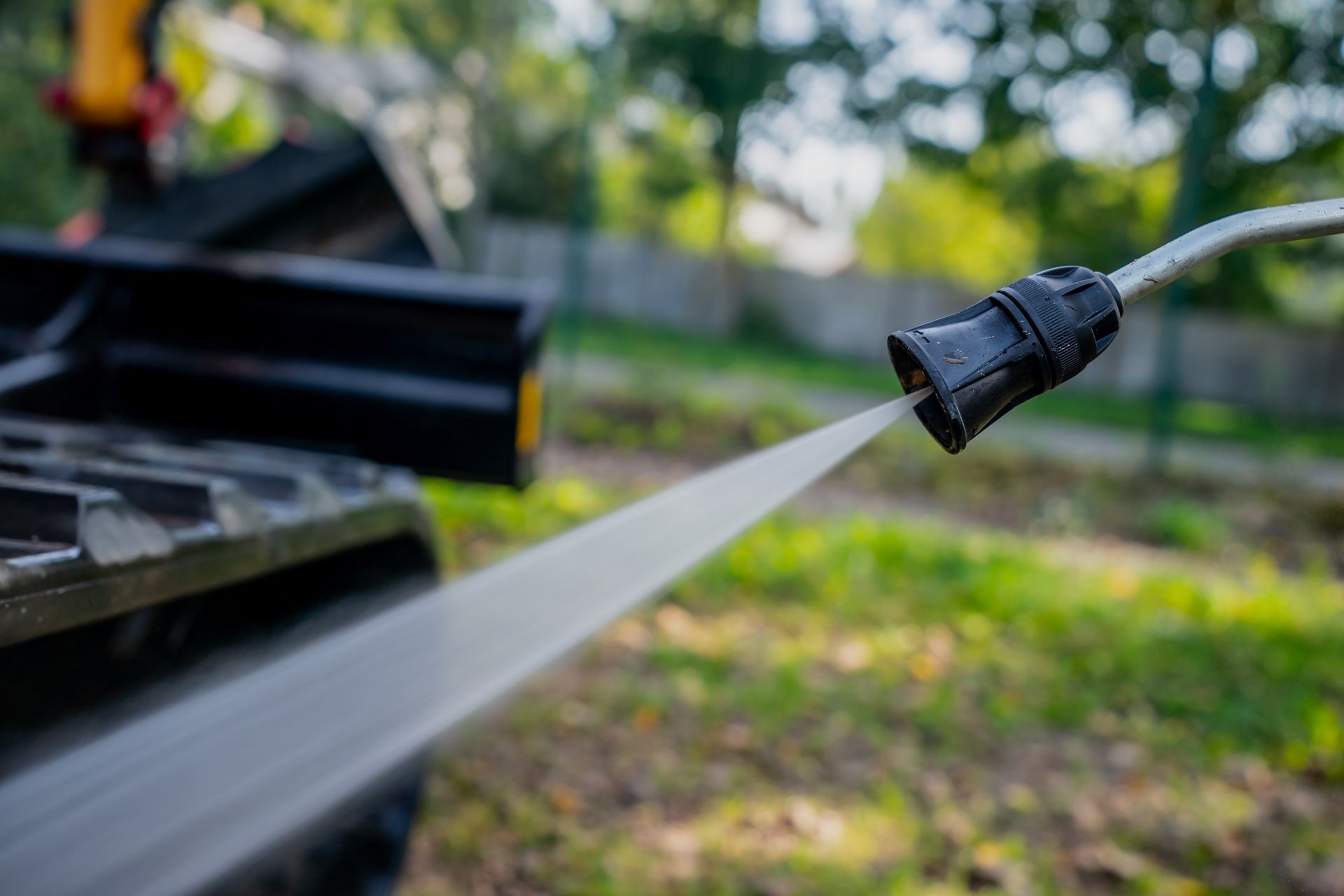 Person hammering a nail into light blue vinyl siding on a building's exterior.