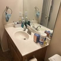 Bathroom sink with faucet, mirror, toiletries and accessories.