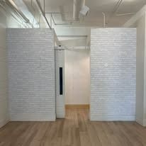 Interior view with white brick walls and wood floor.
