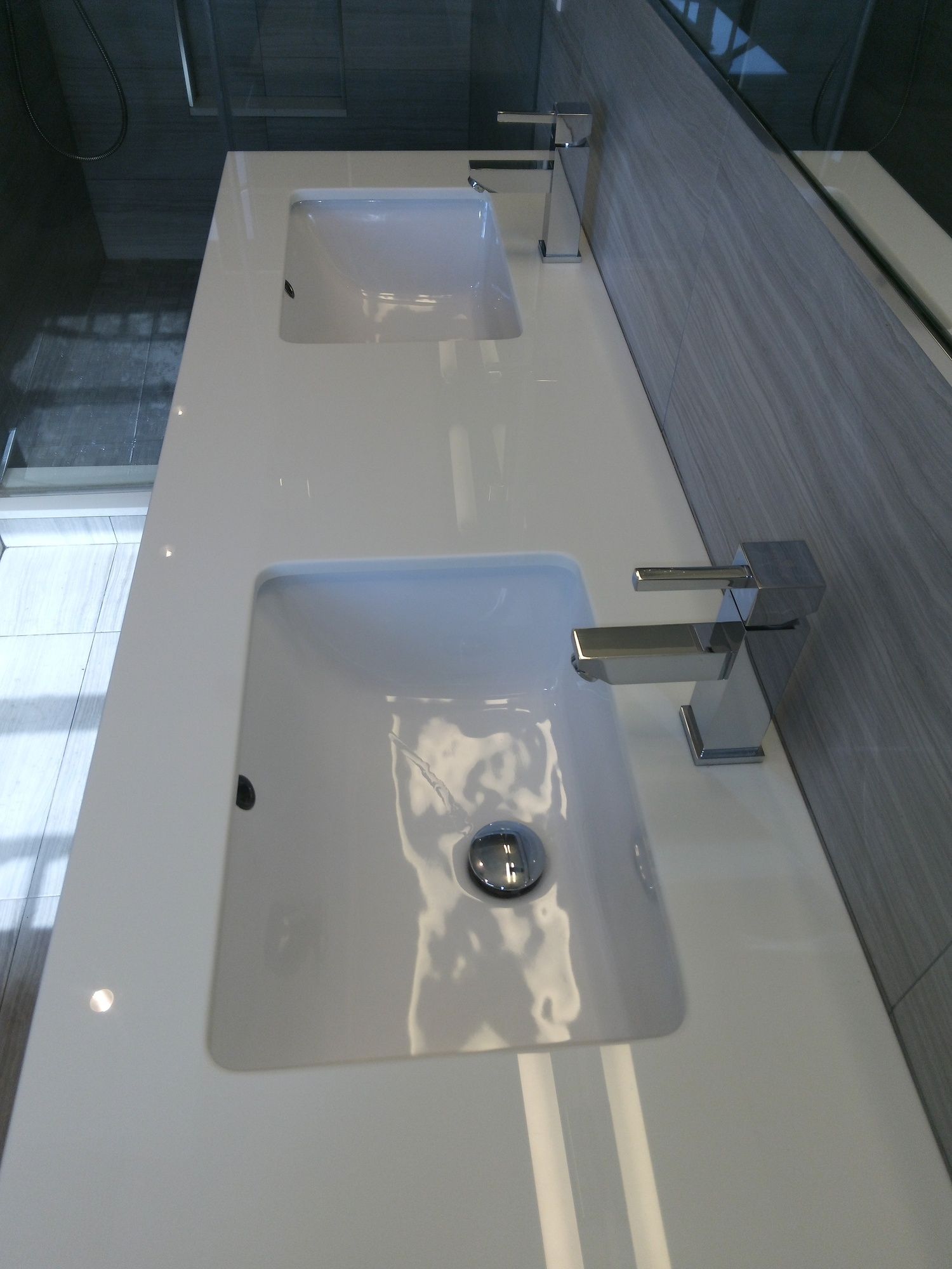 A bathroom with two sinks and two faucets