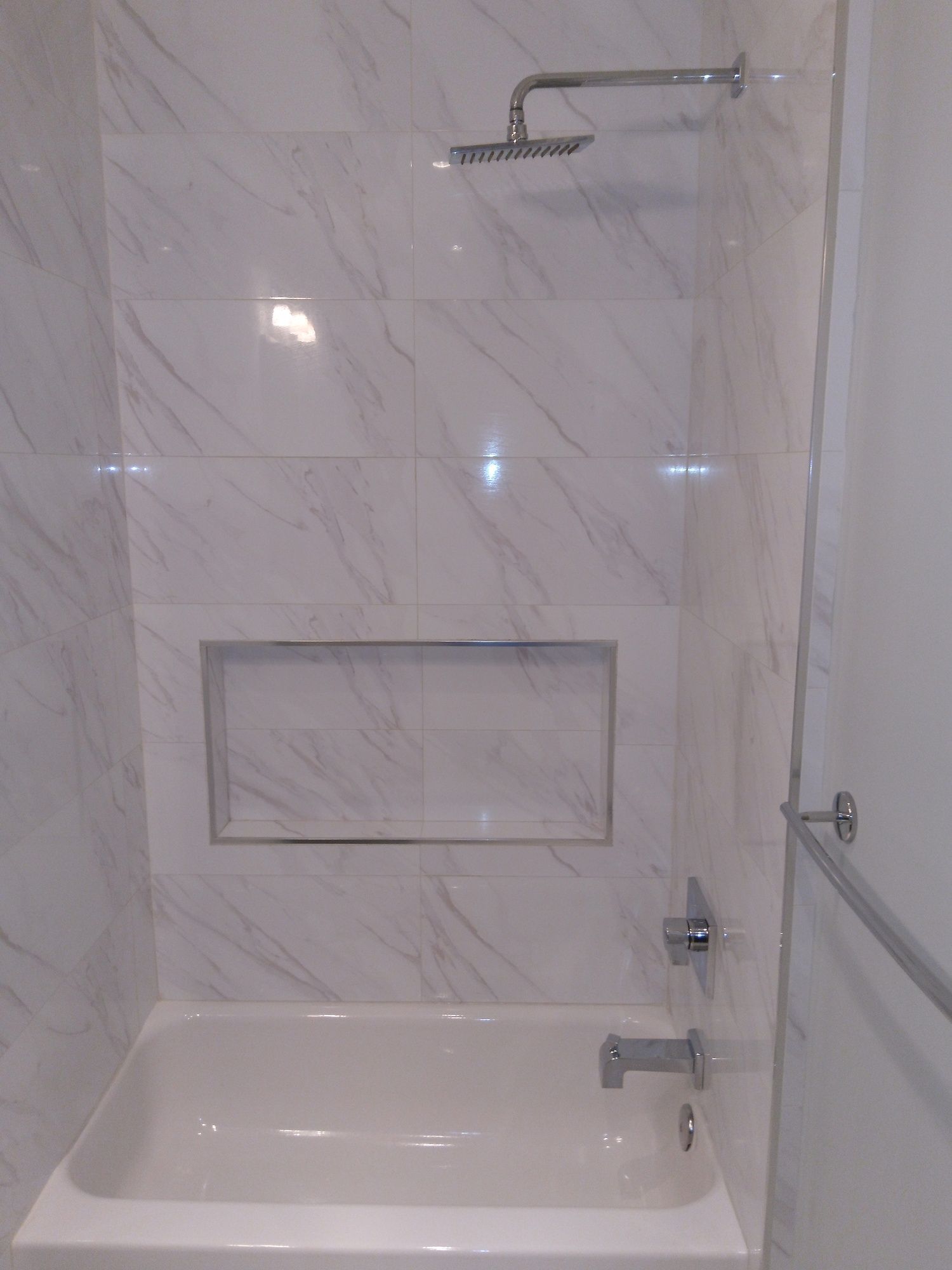 A bathroom with a bathtub and a shower head.