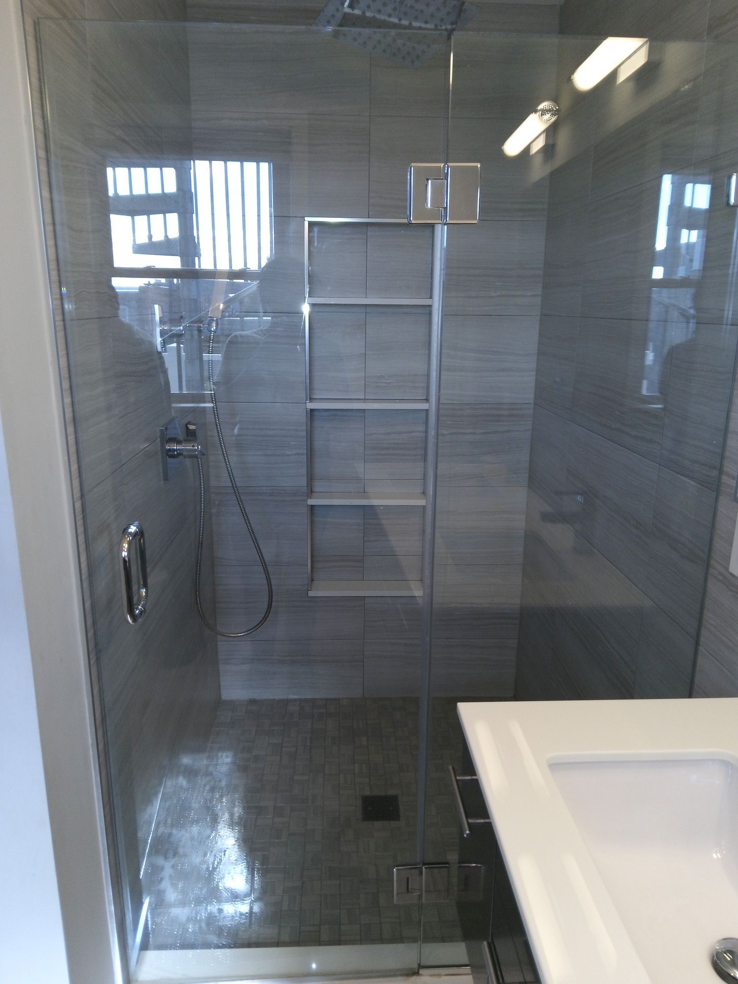 A bathroom with a walk in shower and a sink