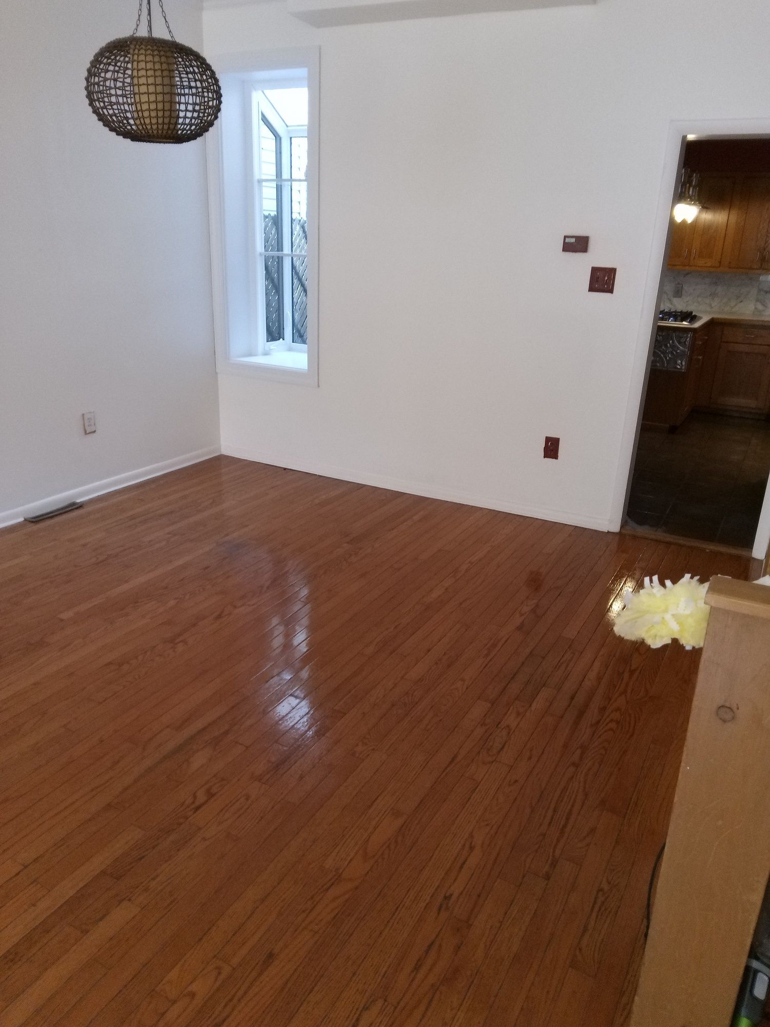 A living room with hardwood floors and white walls.