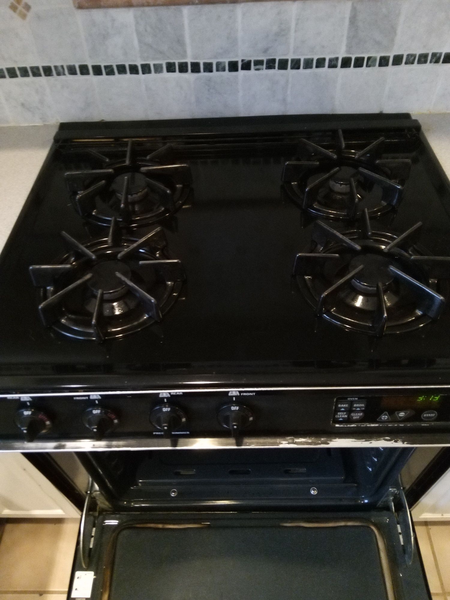 A black stove top oven with the door open