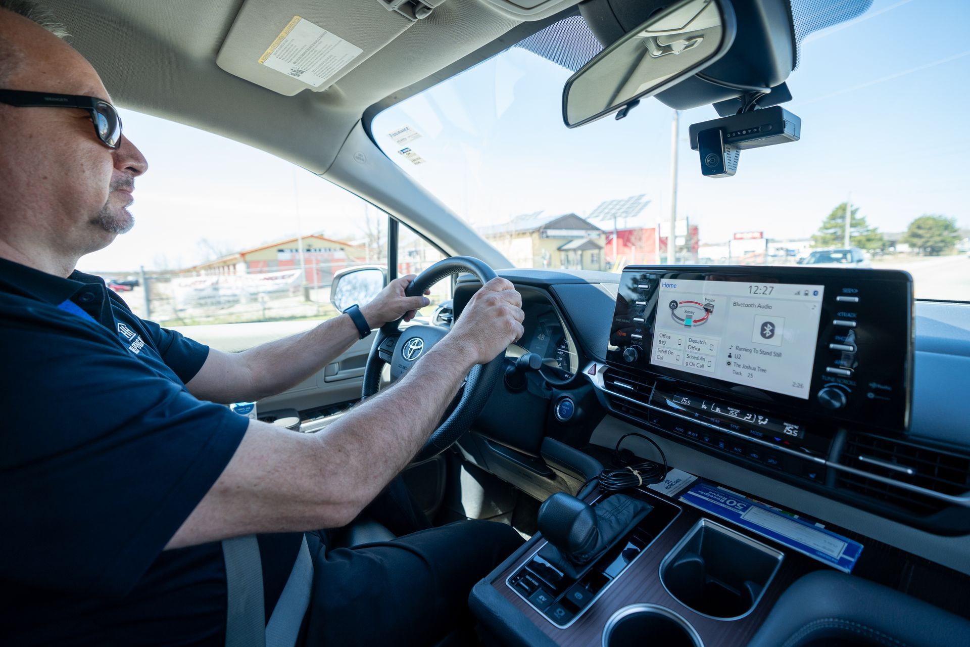 A man is sitting in the driver 's seat of a car.