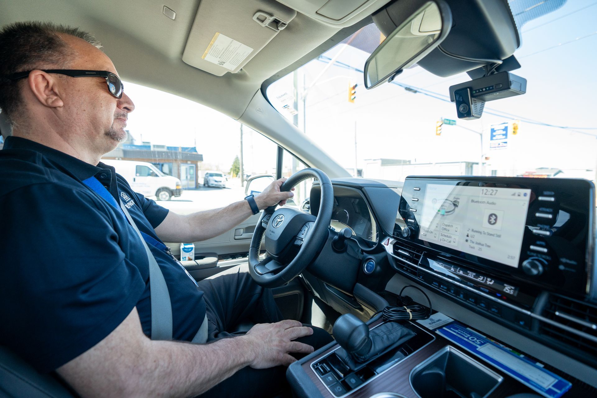 A man is sitting in the driver 's seat of a car.