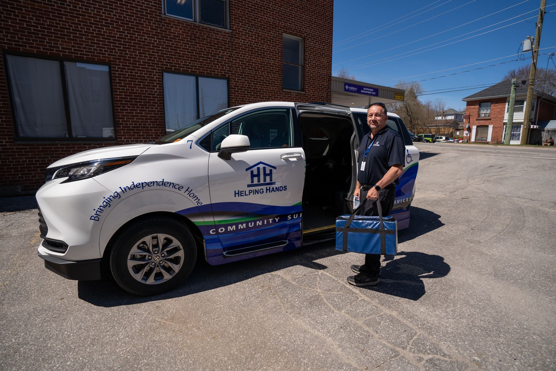 A man is standing next to a car with the door open.