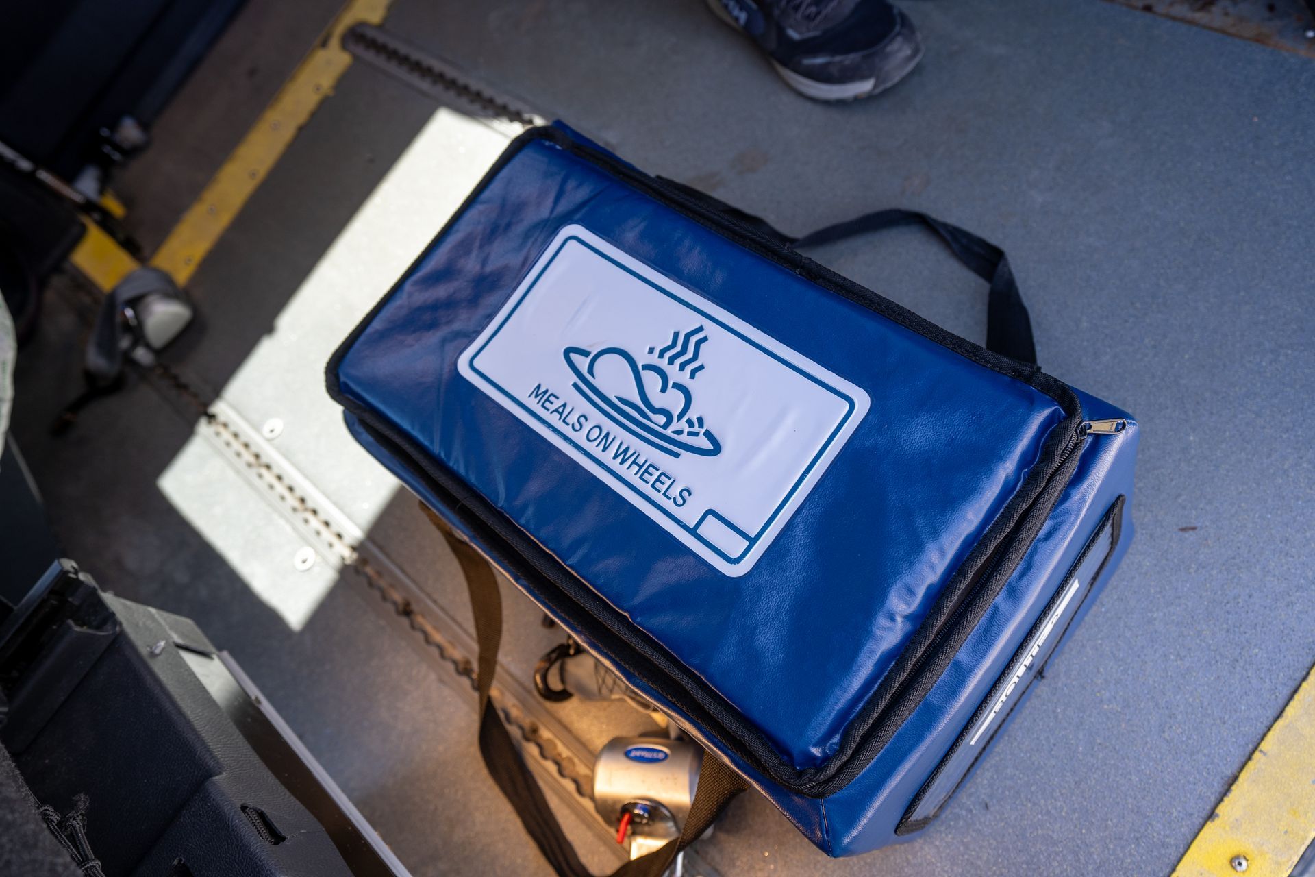 A blue bag with a sticker on it that says 'meals on wheels