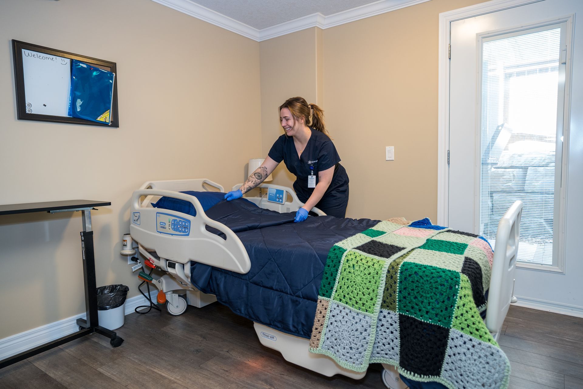 A nurse is making a bed in a hospital room.