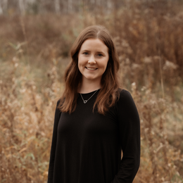 The woman is wearing a black shirt and smiling for the camera.