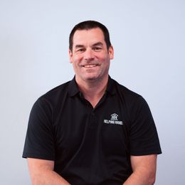 A man wearing a black shirt with the word travel on it