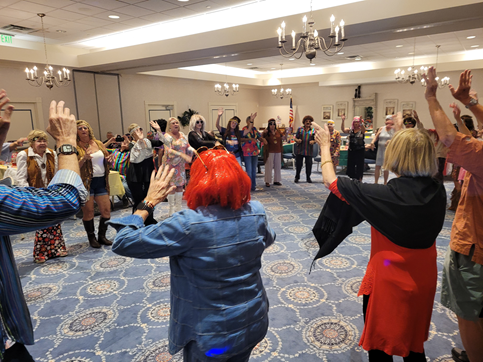 A group of people are dancing in a large room.