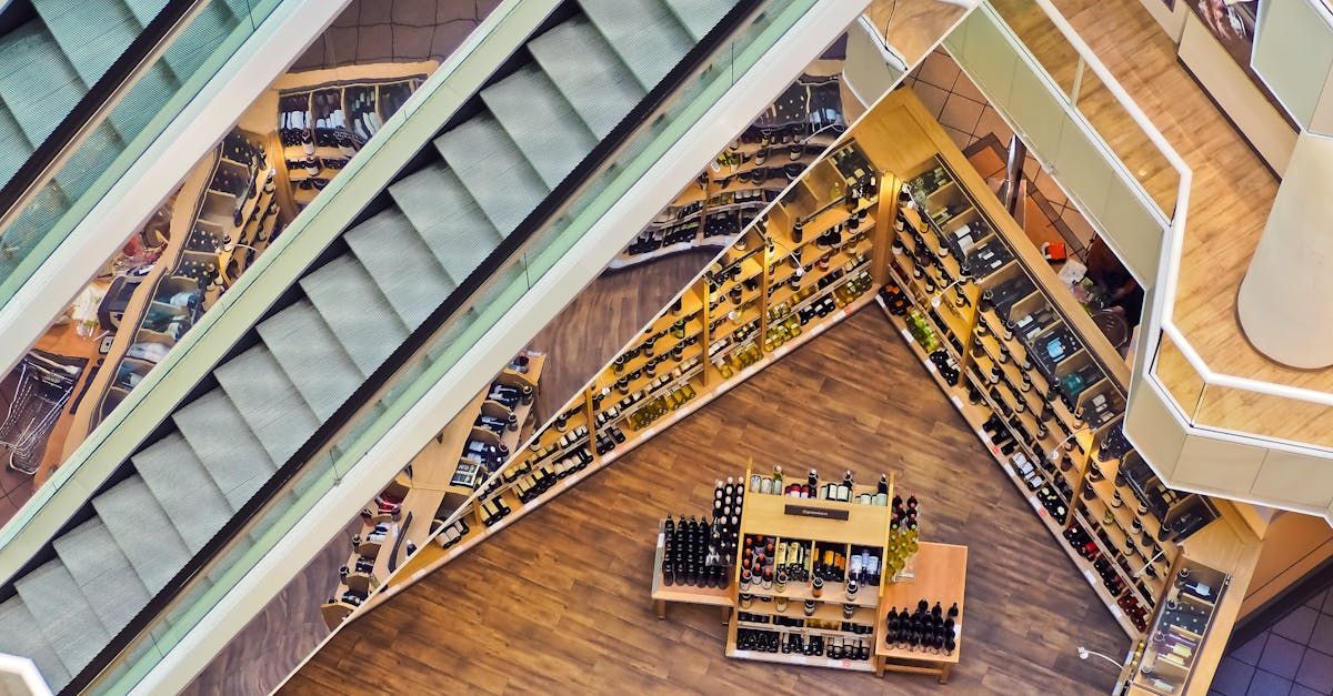 An aerial view of a shopping mall with escalators and shelves.