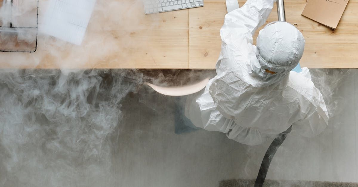 A man in a protective suit is standing in a room with smoke coming out of it.