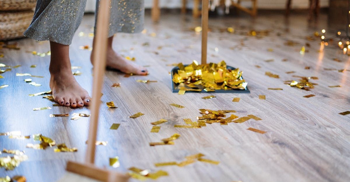 A woman is sweeping the floor with a broom and confetti.