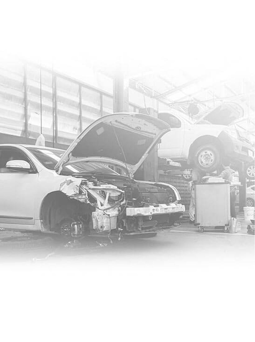 Cars being worked on inside of a repair shop. | Super Express Lube