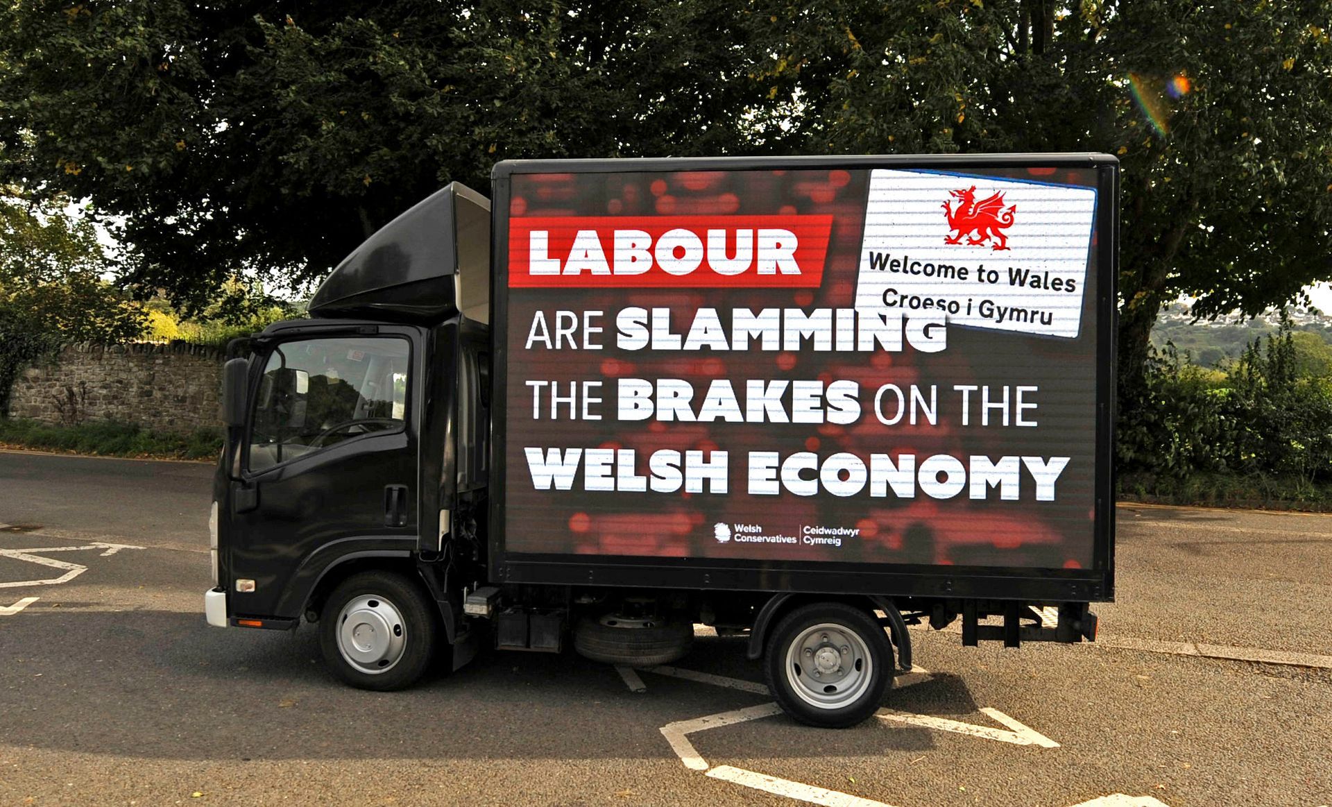 a black digital display van with a sign that says labour are slamming the brakes on the welsh economy