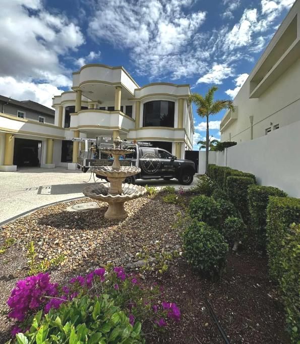 A Large White House With Purple Flowers In Front Of It — Clean Cartel Pressure Washing In Reedy Creek, QLD