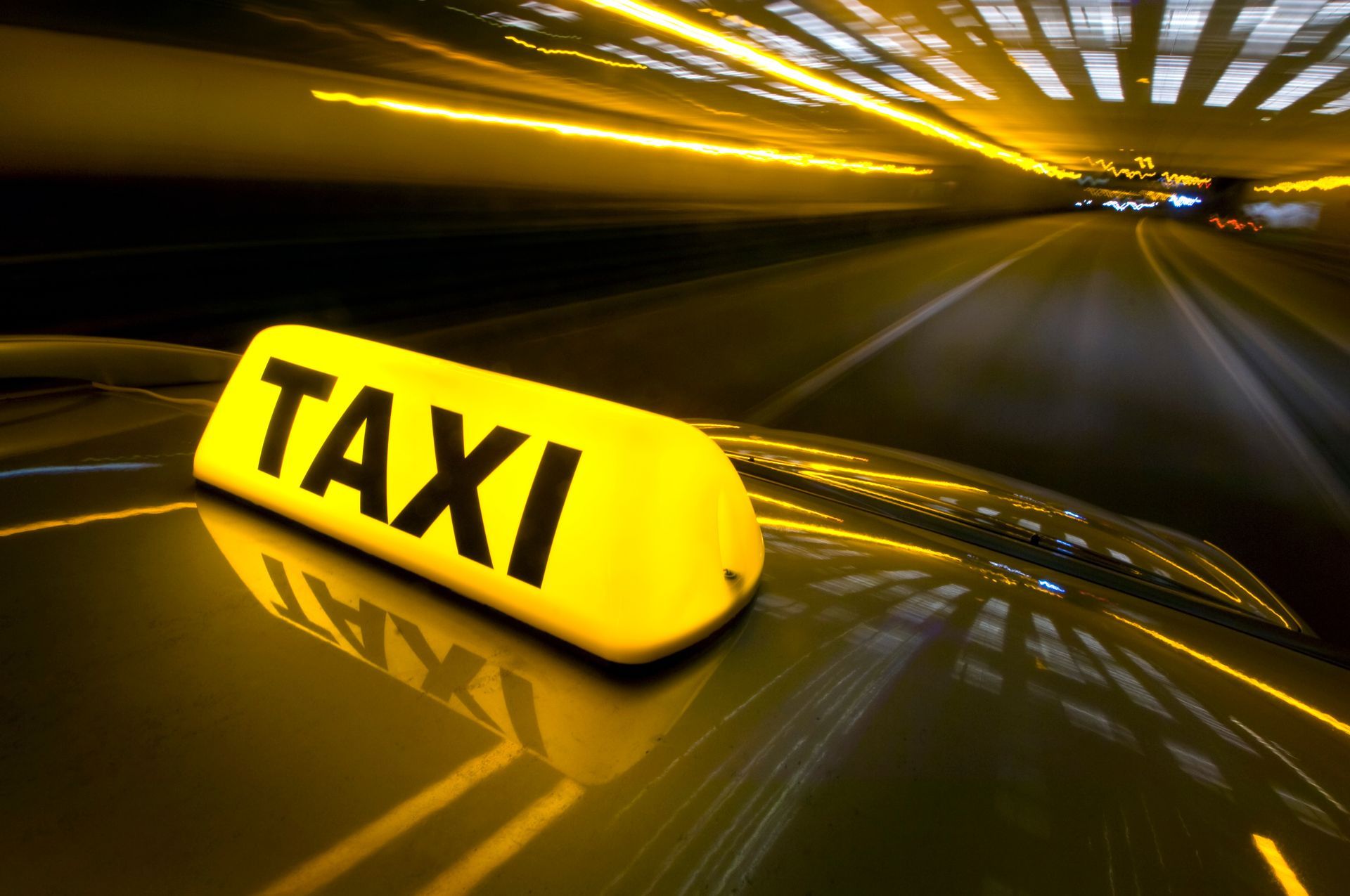 A yellow taxi sign on the side of a car