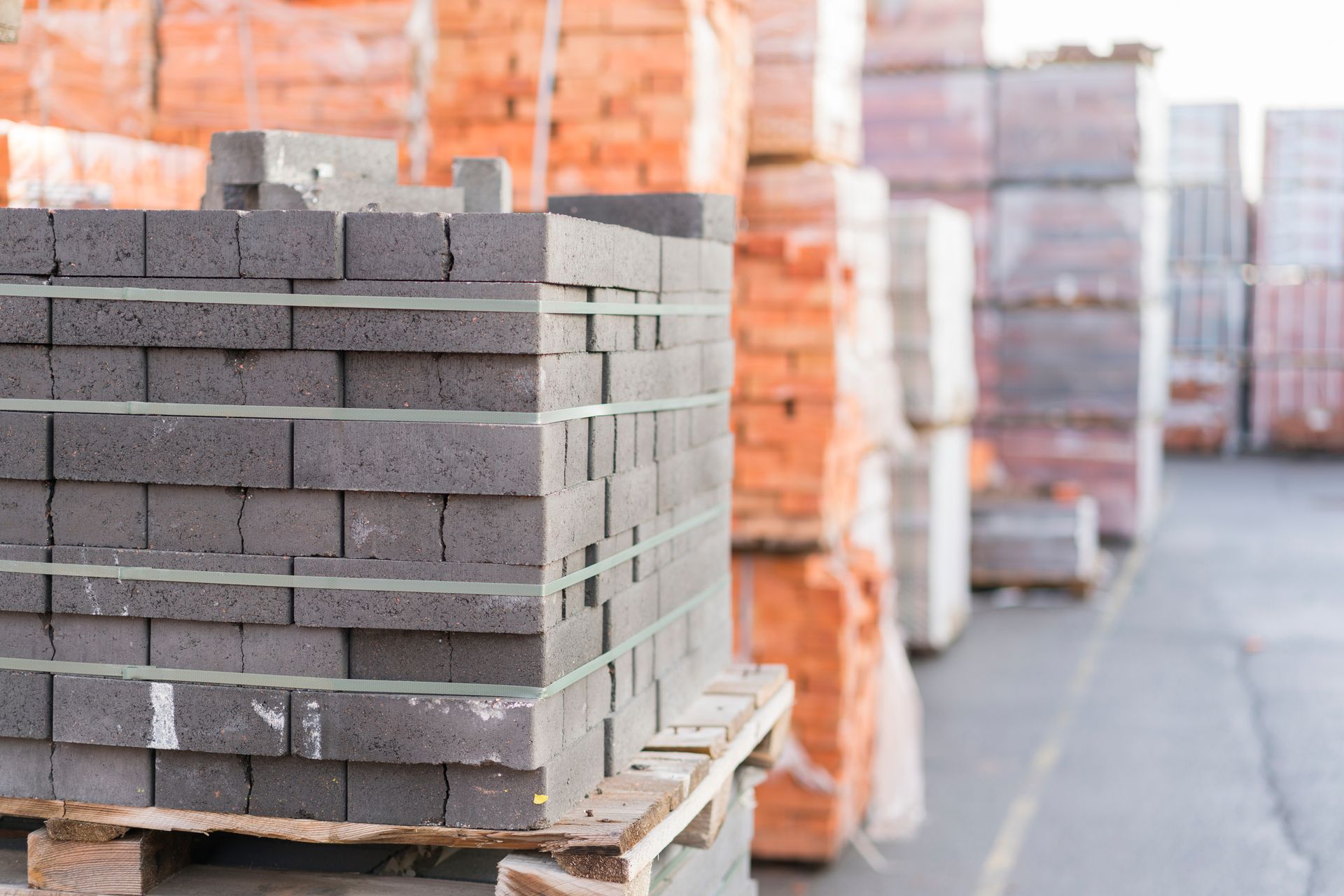 A stack of bricks on a wooden pallet in a warehouse.