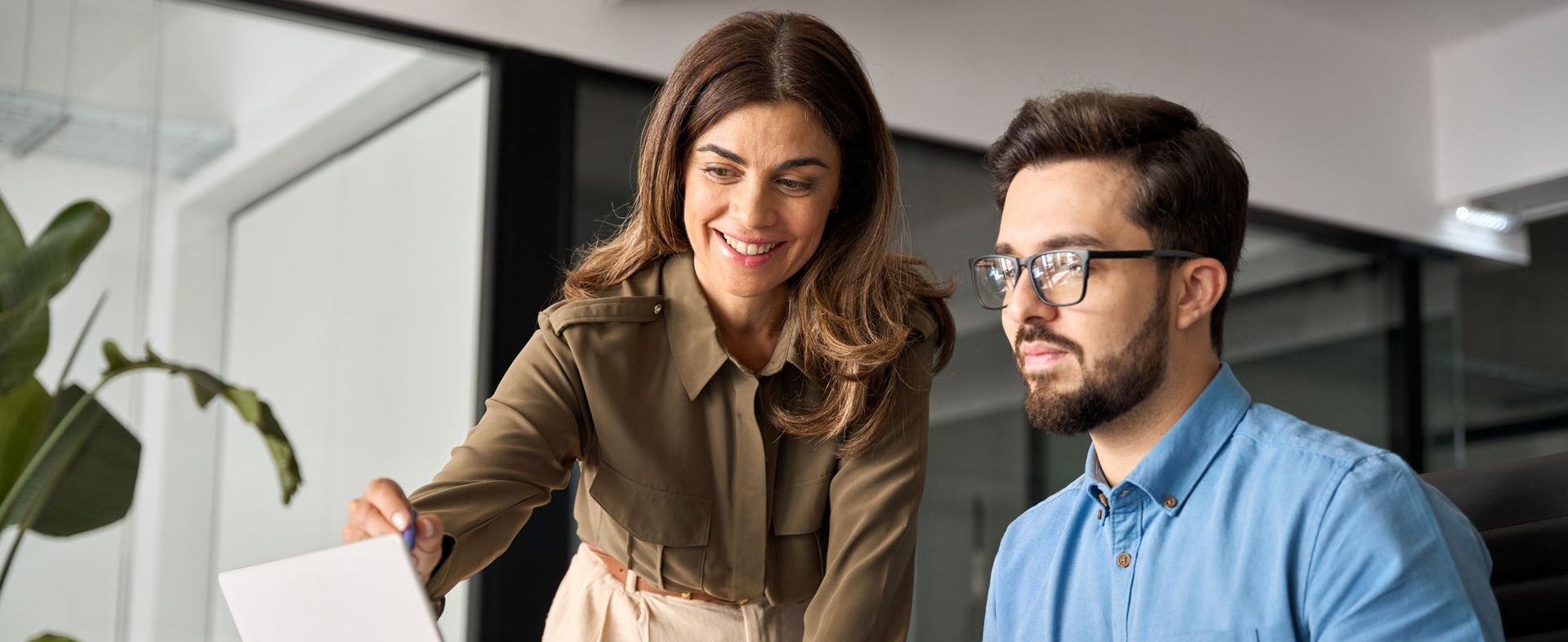 A man and a woman are looking at a laptop together.