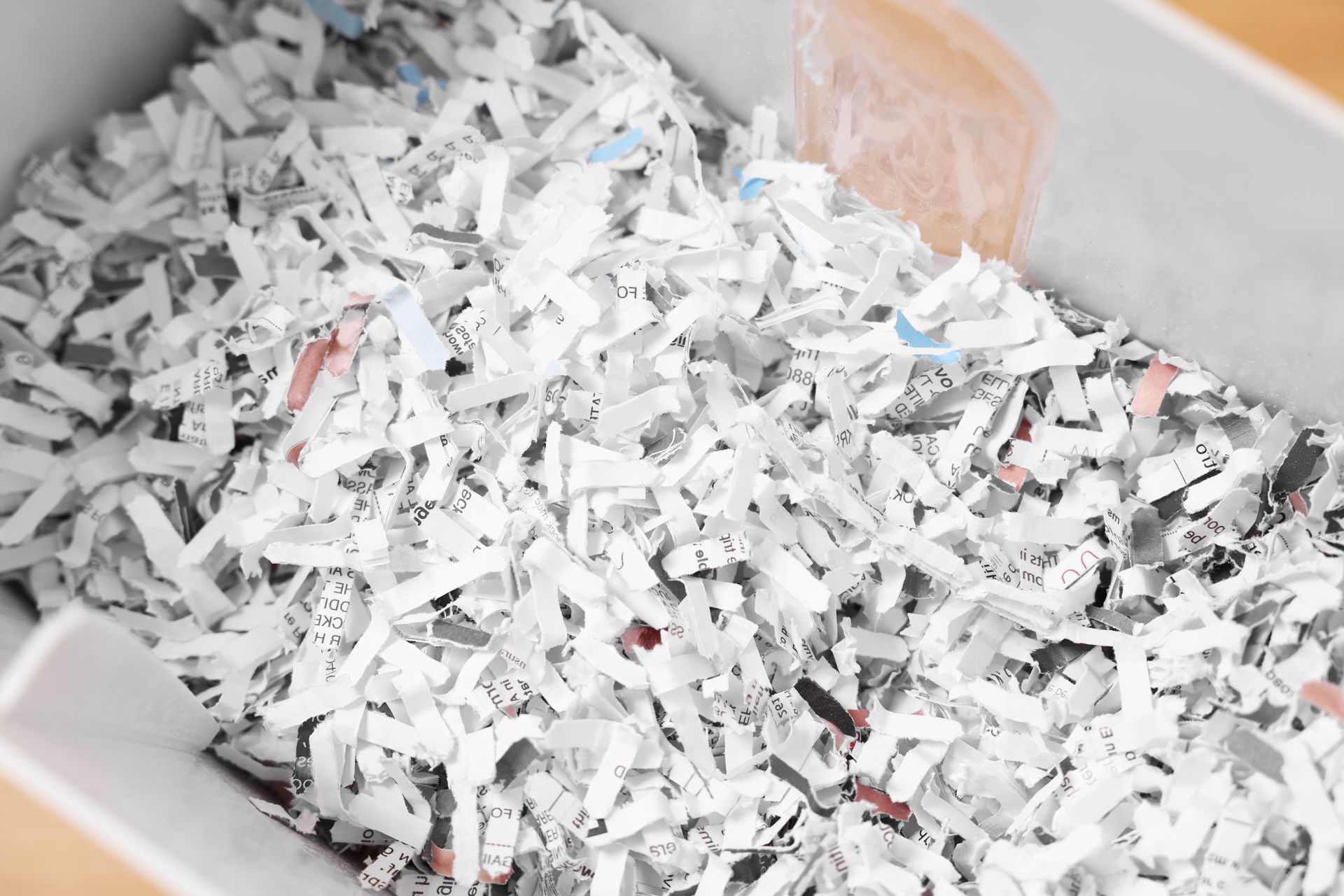 A pile of shredded paper is sitting on top of a wooden table.