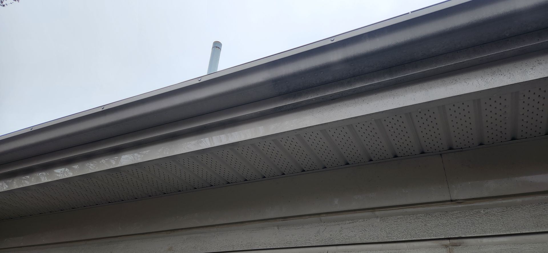 Un gros plan d'une gouttière sur le côté d'une maison.