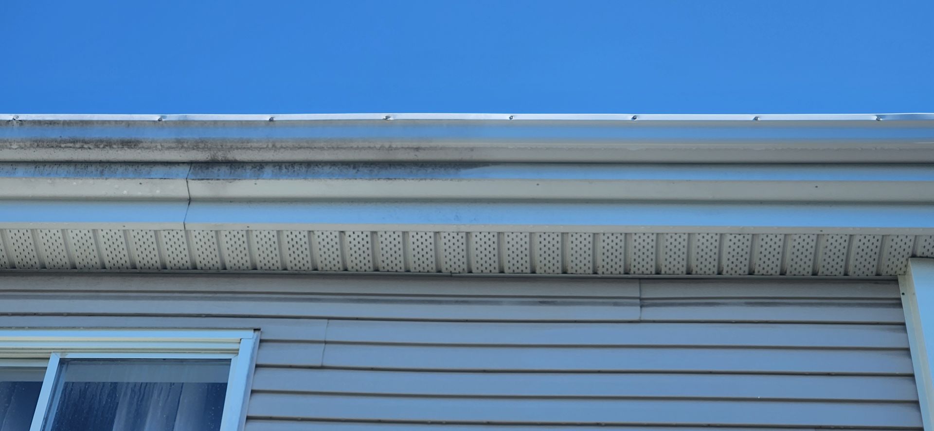 Le toit d'une maison avec un ciel bleu en arrière-plan.