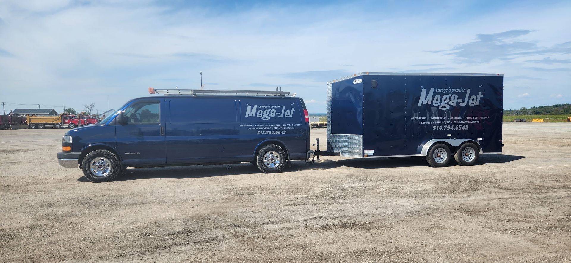 Une camionnette bleue tire une remorque dans un champ de terre.