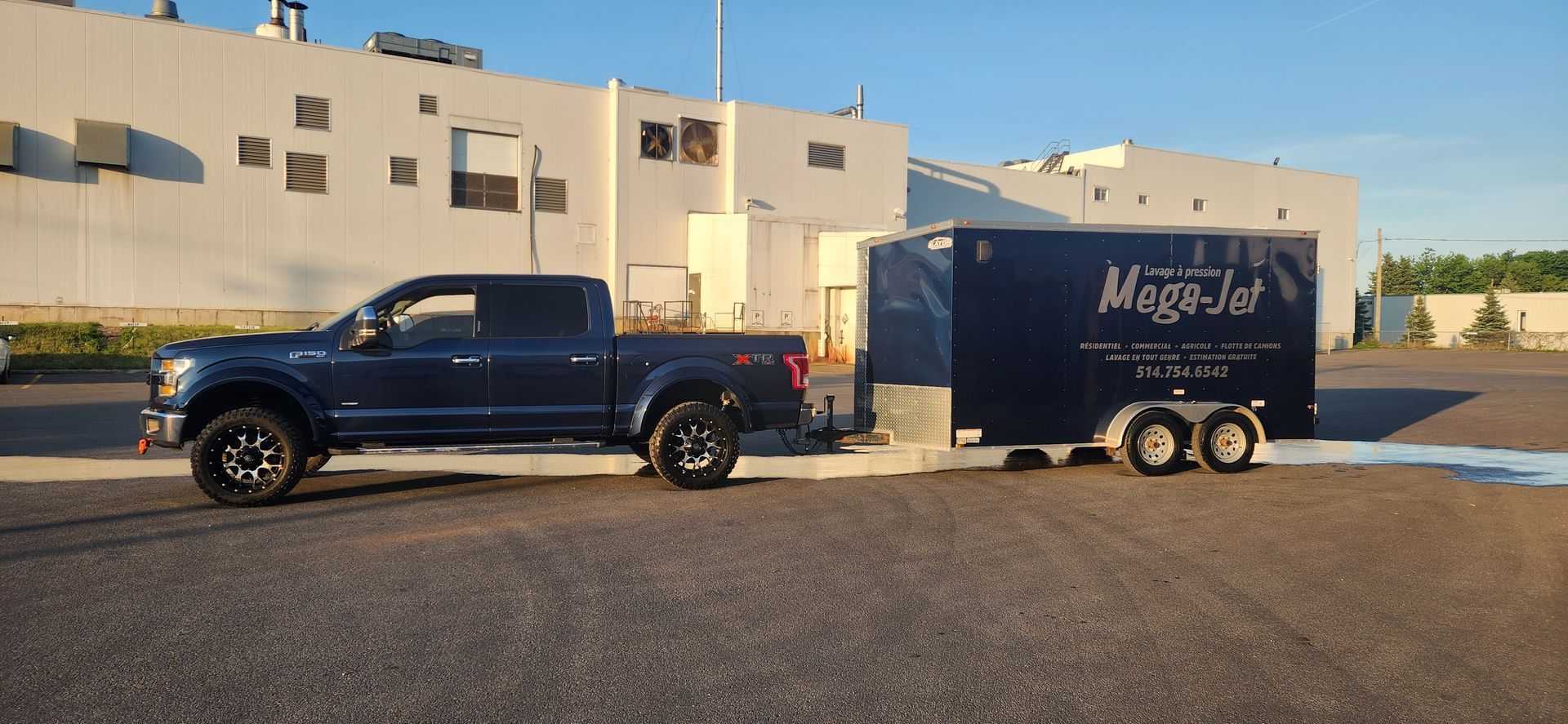 Un camion tire une remorque sur un parking.