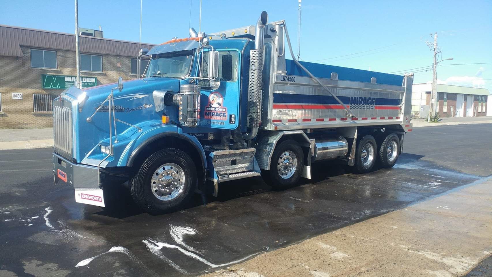 Un camion-benne bleu est garé sur le bord de la route.