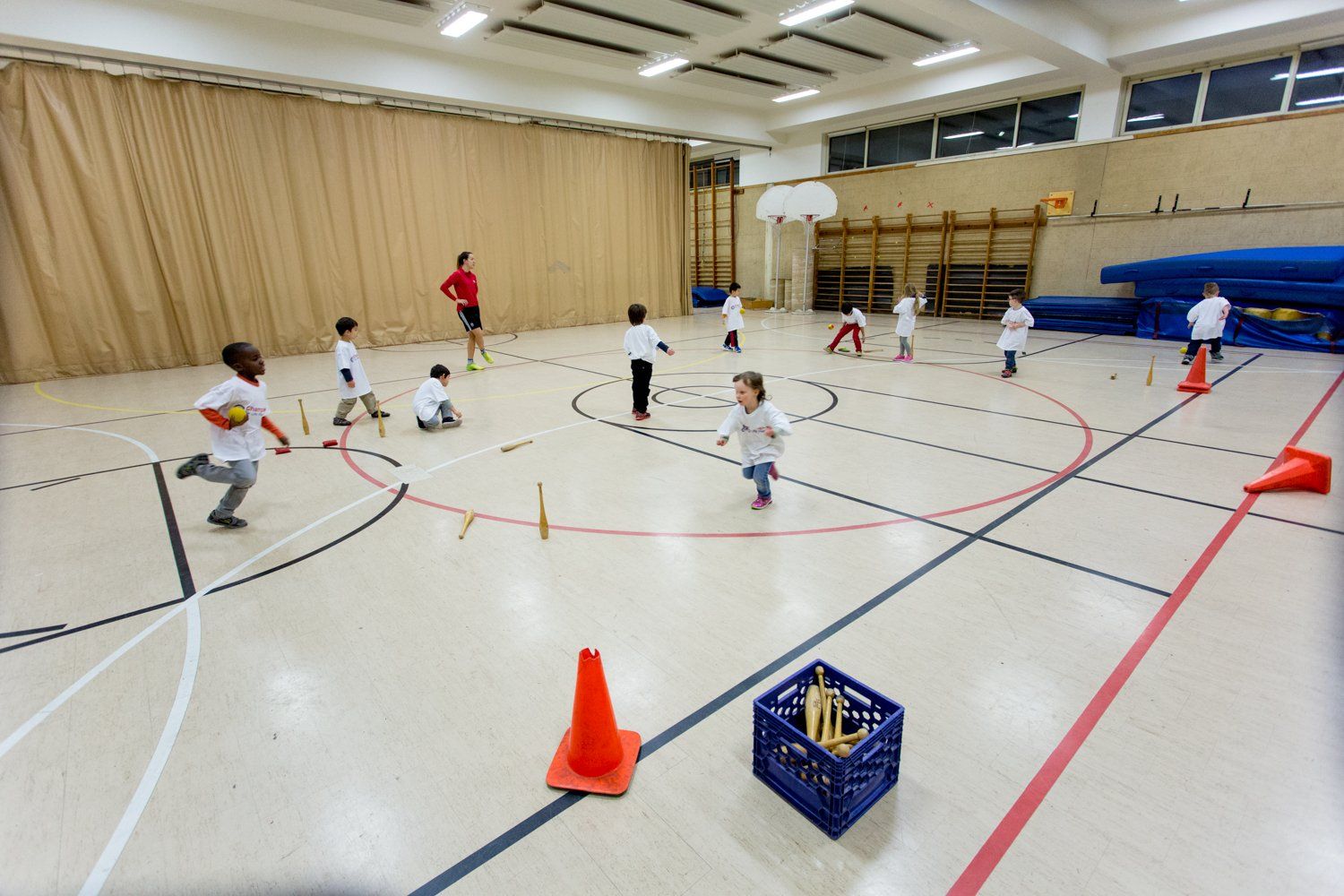 A group of children are playing a game in a gym.