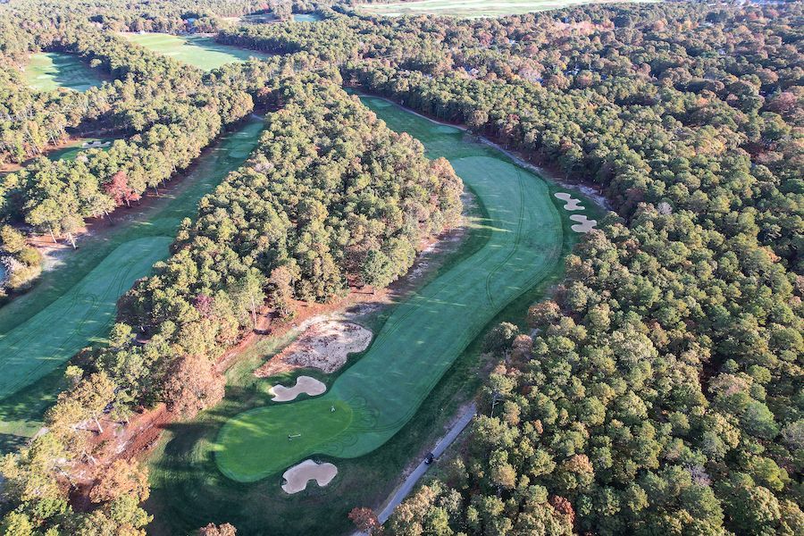 An aerial view of a golf course surrounded by trees
