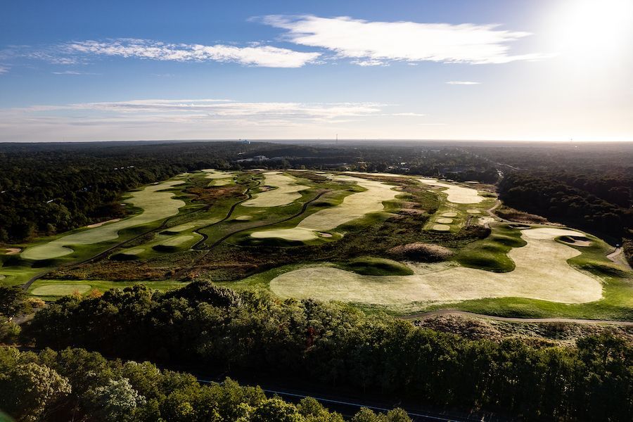 An aerial view of a golf course surrounded by trees.