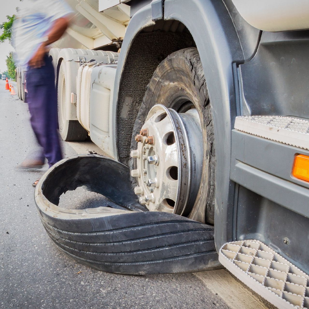 a man is standing next to a truck with a flat tire .