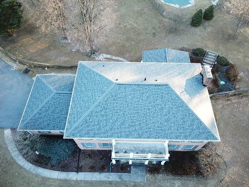 An aerial view of a large house with a pool in the backyard.