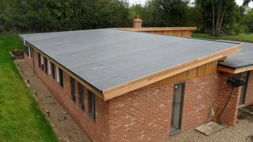 A brick house with a roof that is covered in shingles.