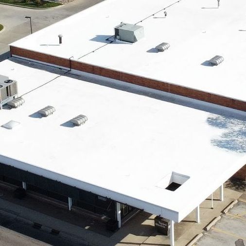 An aerial view of a building with a white roof