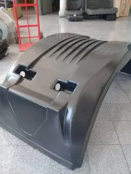 Pasillo en un almacén de autopartes con estantes llenos de ruedas, neumáticos y componentes mecánicos.