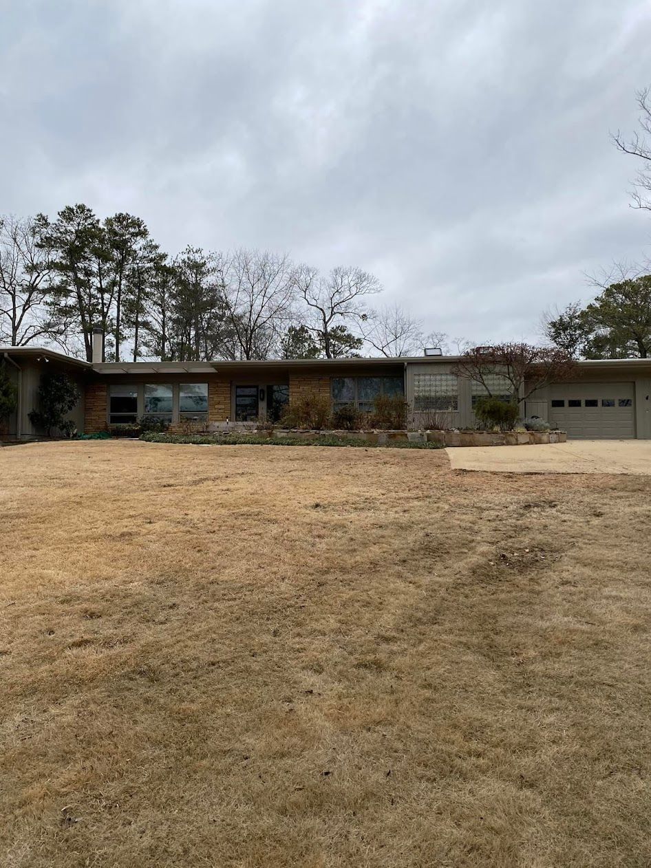 A large house with a garage and a lot of grass in front of it.