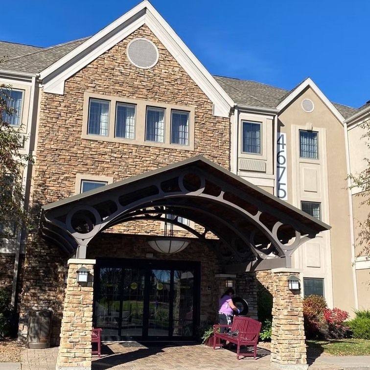 Hotel entrance with a stone facade, arched awning, and person near the door. Building number 4675 is visible.