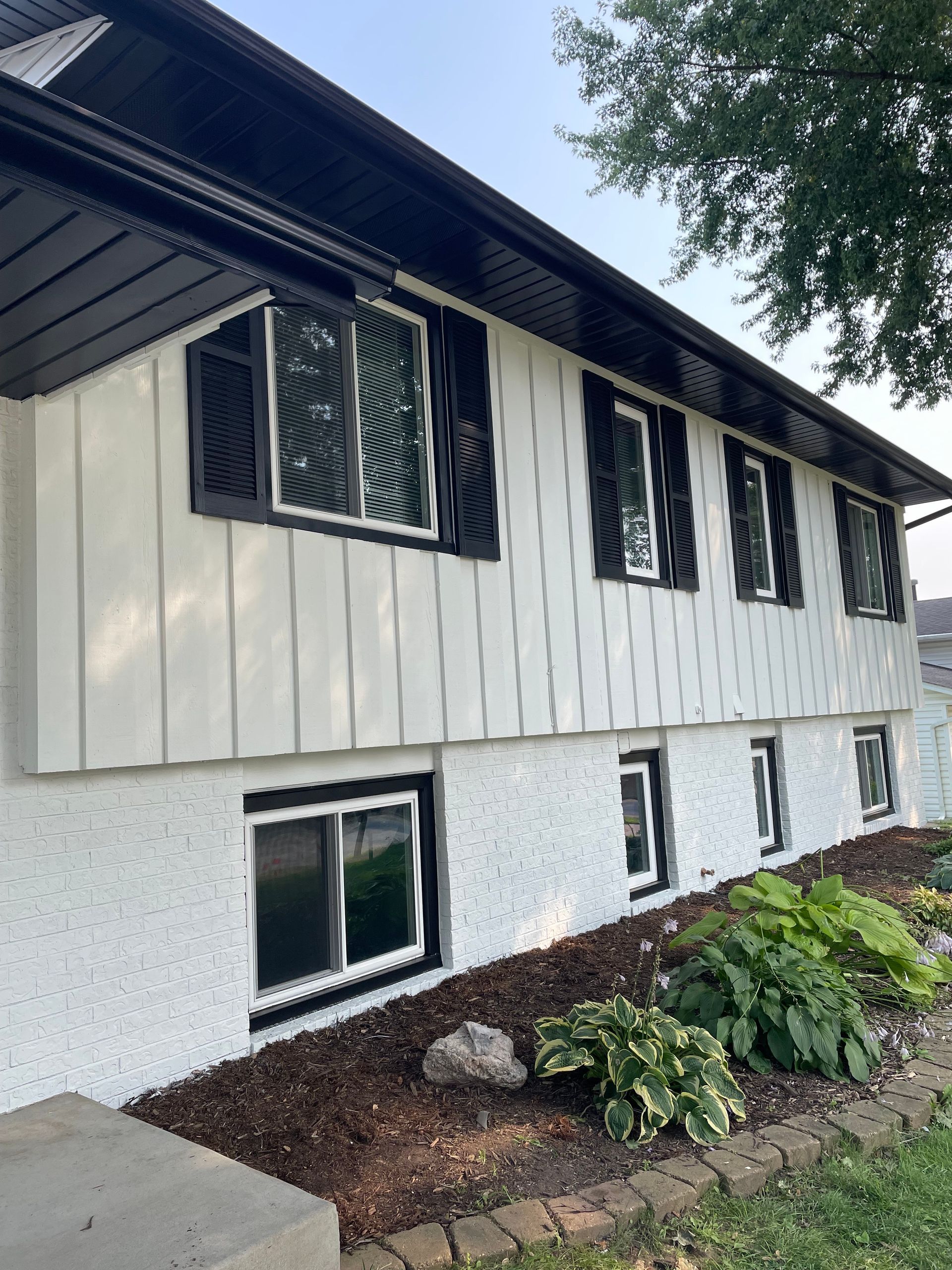 Kitchen with dark wood cabinets, a gas stove, and a microwave. Beige countertops and a tiled floor.