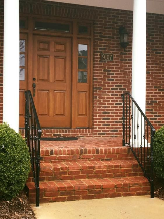 A staircase with a wrought iron railing in the middle of the room