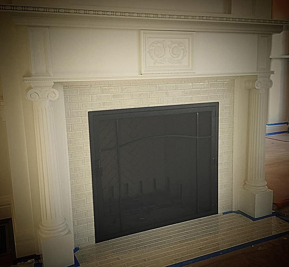 A white brick fireplace with a black door